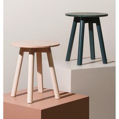 two stools sitting next to each other on top of different colored blocks in the same room