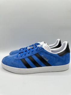 Elevate your footwear game with these stunning adidas Gazelle Originals. The sneakers feature a timeless design made with high-quality suede material and a comfortable foam insole. The lace-up closure ensures a snug fit while the rubber outsole provides excellent traction. Perfect for any occasion, these sneakers are versatile enough to complement any outfit. The blue, black, and white color scheme adds a pop of color to your wardrobe, and the limited edition style code (IG0666) guarantees you stand out from the crowd. Get your hands on these adidas Gazelle sneakers today! Adidas Skate Shoes With Boost Midsole, Leather Adidas Sneakers For Jogging, Custom Suede Sneakers For Sports, Adidas Logo Custom Lace-up Sneakers, Custom Adidas Logo Lace-up Sneakers, Custom Suede Sneakers With Cushioned Footbed For Sports, Cushioned Suede Custom Sneakers For Sports, Adidas Suede Sneakers With Round Toe, Casual Adidas Logo Suede Skate Shoes