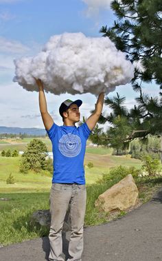 a man holding up a large cloud over his head