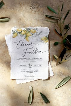 an old piece of paper with olives and leaves on it next to the wedding stationery