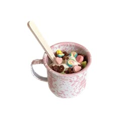 a pink mug filled with cereal and marshmallows