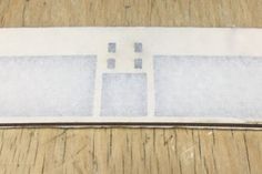 the back side of an electronic device with white paper on it and two small squares