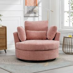 a living room with a pink chair and rug