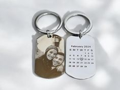 two personalized key chains with a photo and date printed on them, sitting next to each other