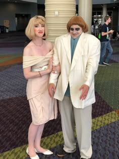 a man and woman dressed in white posing for the camera