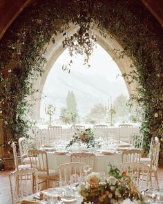 an outdoor wedding venue with tables and chairs set up for a formal function in front of an arched doorway