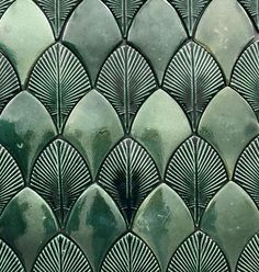 a close up view of an art deco tile pattern in green and grey tones with wavy lines