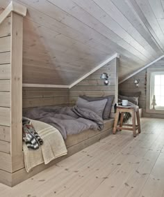 an attic bedroom with wooden walls and flooring