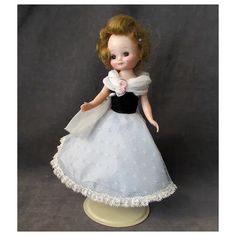 a doll is dressed in a white and black dress