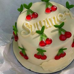 a white cake with cherries and the word summer written on it in frosting