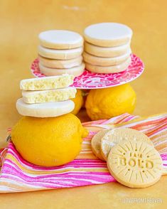 cookies and lemons are stacked on top of each other in front of two plates