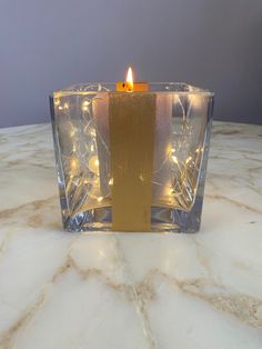 a lit candle sitting on top of a marble table