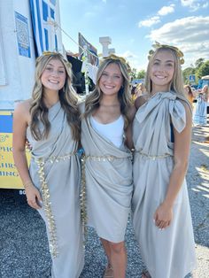 three girls dressed in roman garb posing for the camera