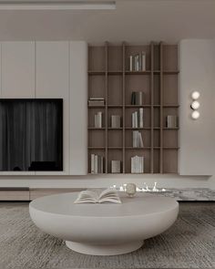 a modern living room with bookshelves and a large coffee table in the middle