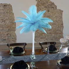 there is a tall blue feather centerpiece on the table