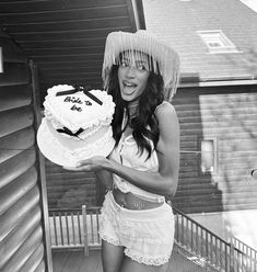 a woman holding a cake with the number twenty five on it and an umbrella over her head