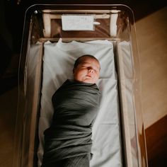 a baby is laying in a clear box