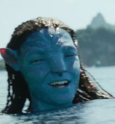 a man with blue paint on his face in the water