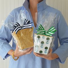 a woman holding two wrapped presents in plastic bags with bows and ribbons on their handles