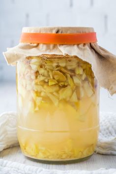 a jar filled with pickled onions on top of a white cloth covered tablecloth