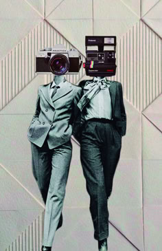 two people in suits and ties with a camera on their heads, one holding the other's hand