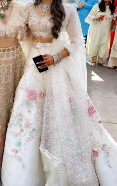 two women dressed in wedding outfits standing next to each other