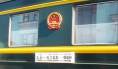 the side of a green and yellow train with chinese characters on it's windows