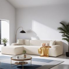 a living room with a large white couch and coffee table in front of a window