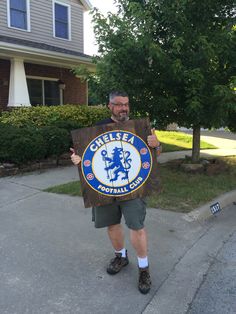 a man holding up a sign that says gerfezz football club on it