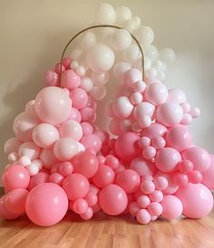 pink and white balloons are arranged on the floor