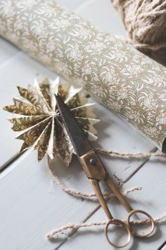 a pair of scissors sitting on top of a table next to a roll of twine