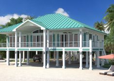 a large white house sitting on top of a sandy beach