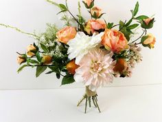 a vase filled with lots of flowers on top of a table