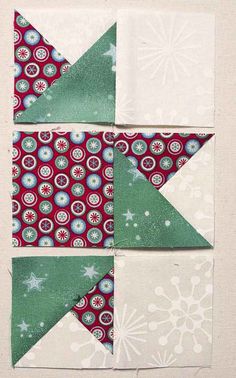 the block is made up of green and red fabric with white snowflakes on it