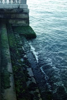 a person standing on top of a pier next to the ocean