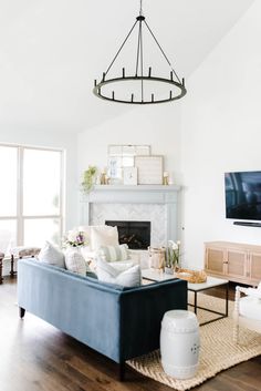 a living room filled with furniture and a flat screen tv mounted on the wall over a fireplace