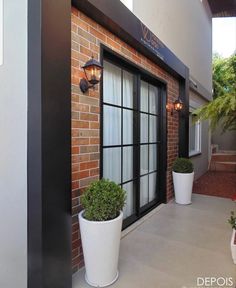 two potted plants are on the outside of a building's front porch area