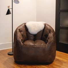 a brown chair with a white fur pillow on it