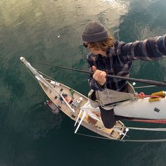 a man standing on top of a boat in the water