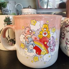 three coffee mugs with different designs on them sitting on a counter top next to each other