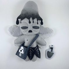 a stuffed animal is sitting next to a small bag with a skull and crossbone on it