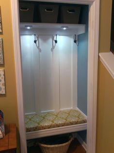 the inside of a white wooden bench with storage bins