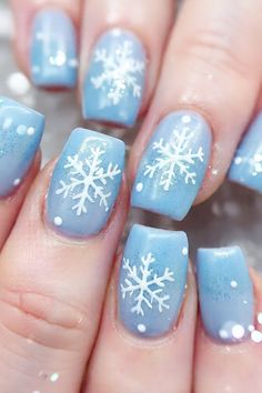 Add some magic to your nails with these snowflake-inspired designs. Perfect for the holiday season How To Paint Snowflakes On Nails, Light Blue Nails With Snowflakes, Snow Flake Nails Design, Easy Snowflake Nails, Snow Nails Winter Blue, Blue Winter Nails Snowflakes, Winter Theme Nails, Winter Nails With Snowflakes, Snowflake Nails Simple