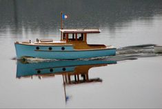 a small blue boat floating on top of a lake