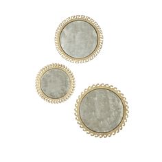 two round mirrors sitting on top of a white table next to each other with gold trimming