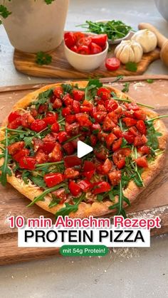 a pizza sitting on top of a wooden cutting board next to other food and vegetables