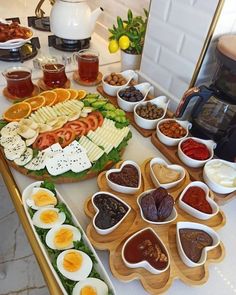 an assortment of food is arranged on a counter top with bowls and spoons in the shape of hearts