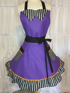 a purple and black polka dot apron dress on a mannequin headdress