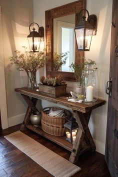 a wooden table topped with vases filled with flowers next to a wall mounted mirror