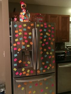 a refrigerator covered in colorful stickers and magnets next to a stove top oven